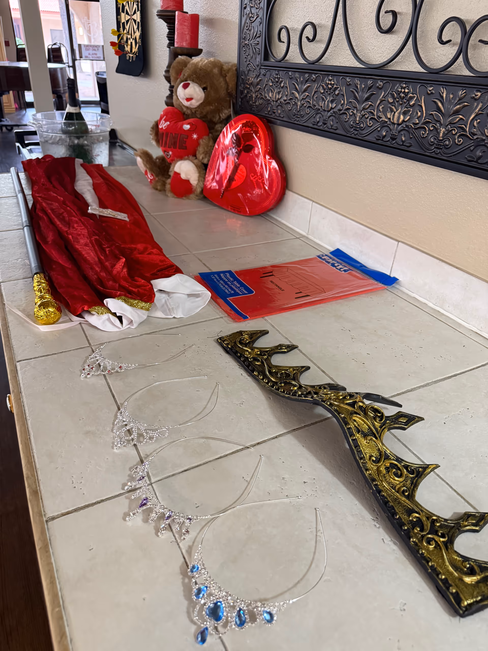 Decorative holiday props and tiaras arranged on a tiled lobby counter.