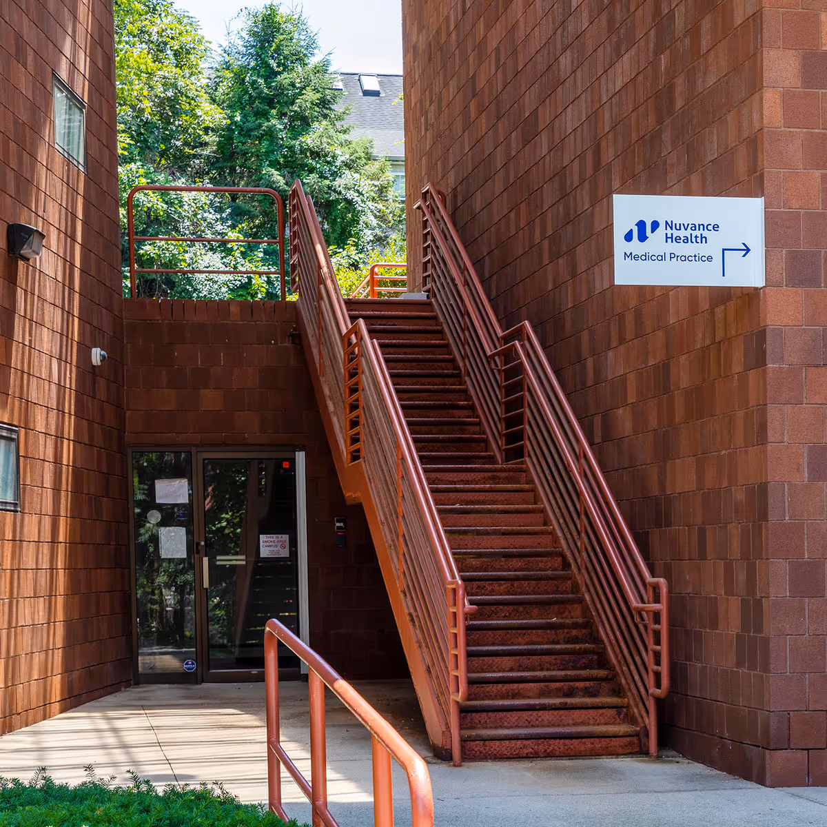 Brick building exterior with a central red staircase and a Nuvance Health sign.