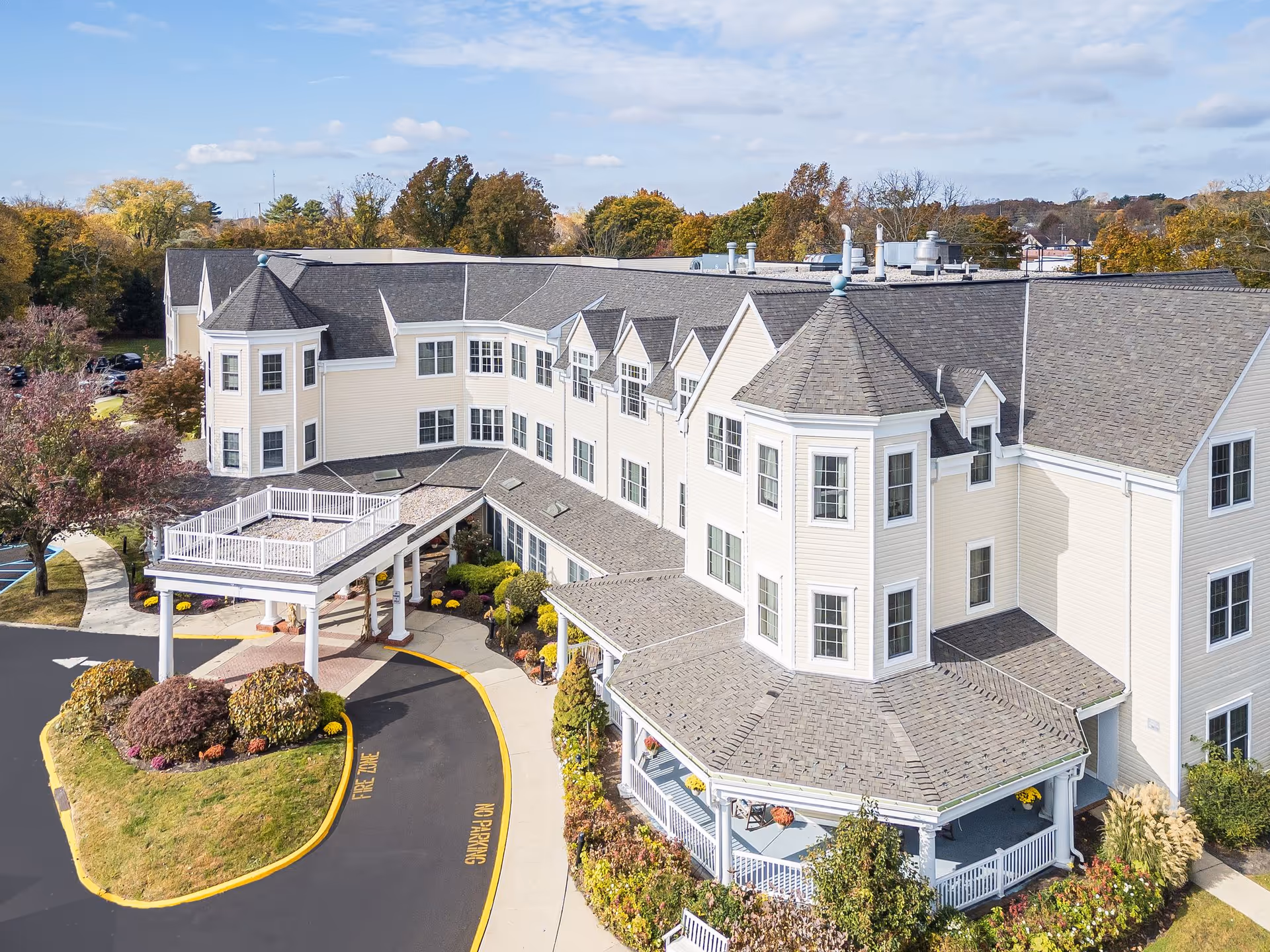 A large cream-colored senior living building with a curved entry and landscaped grounds.