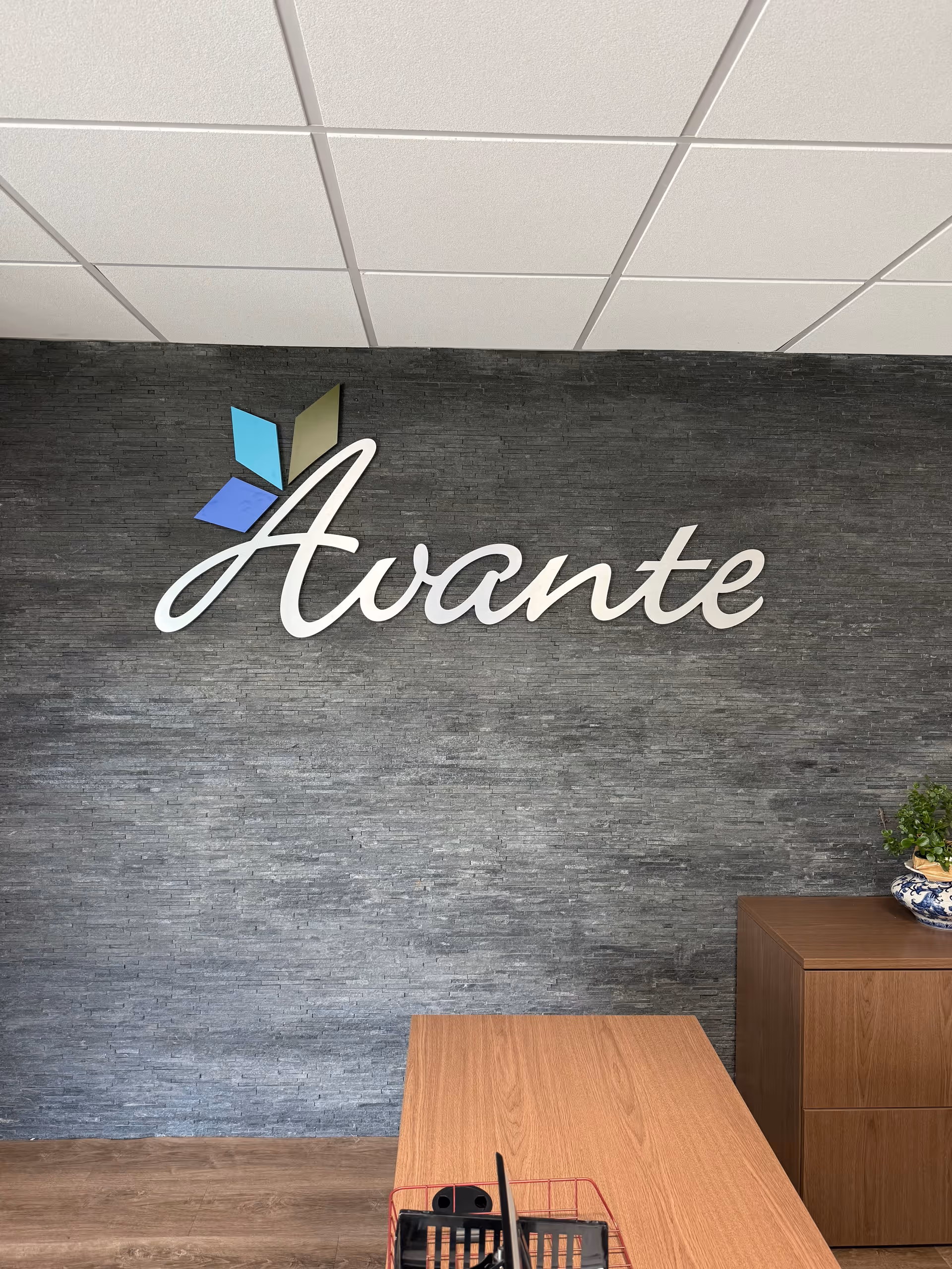 Interior lobby featuring the Avante logo on a textured wall with a desk.