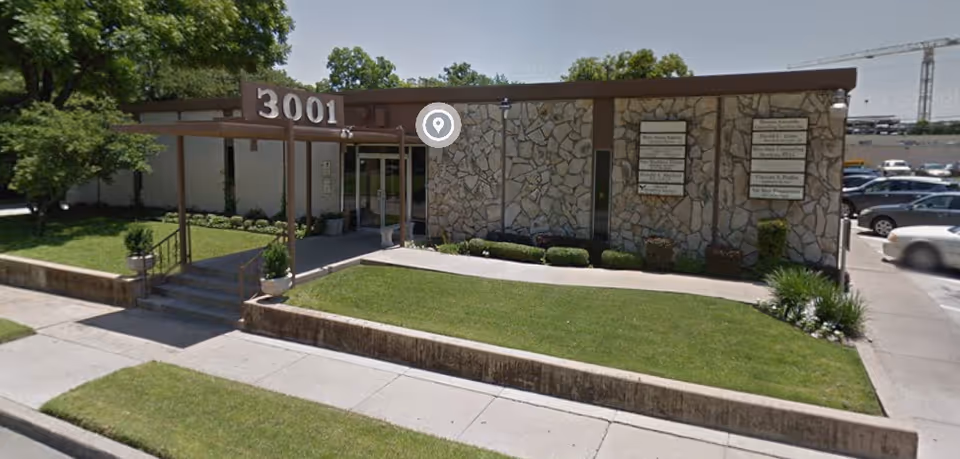 Exterior of a stone-faced senior living facility with landscaped lawn and 3001 address.