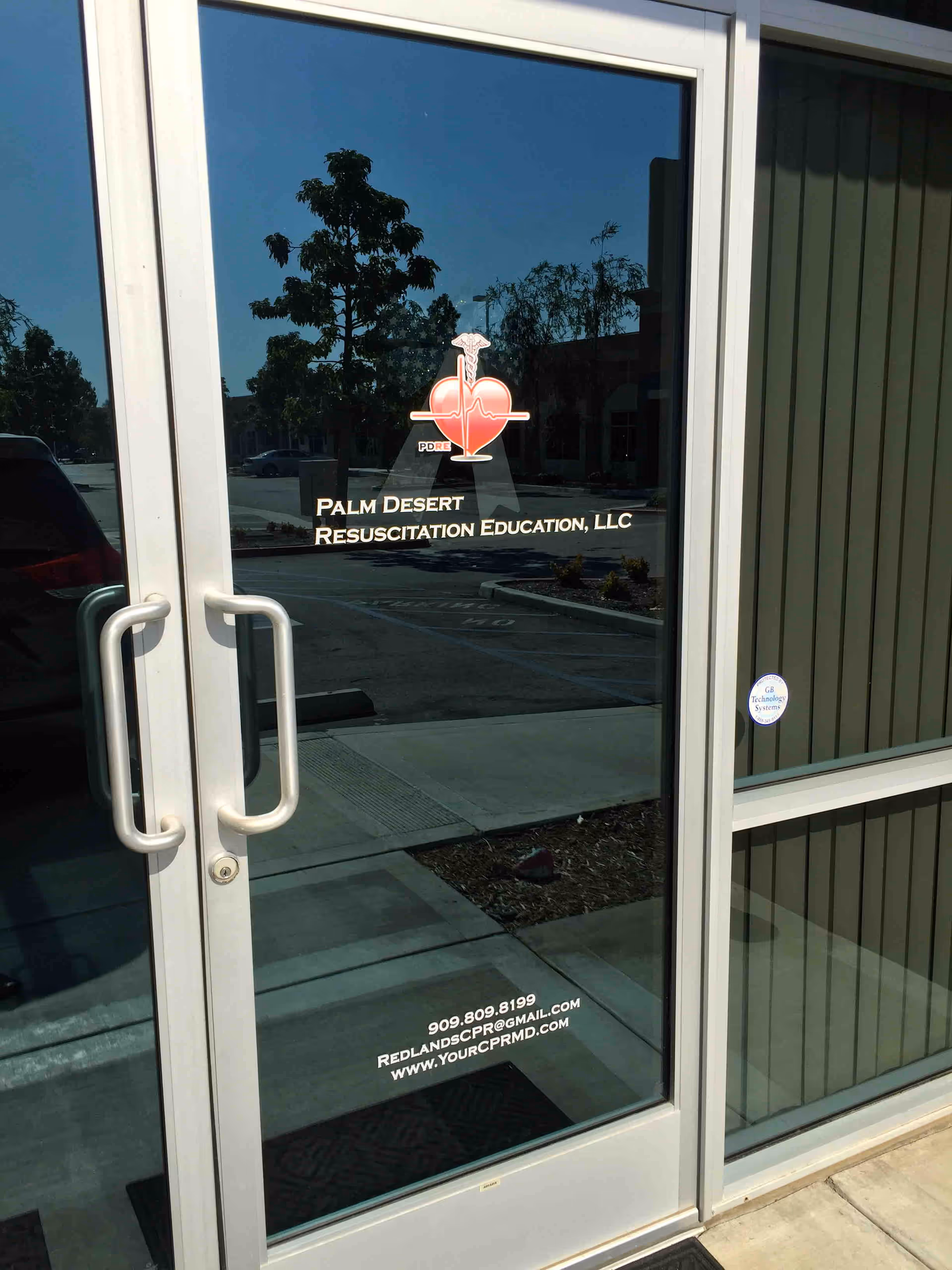 Glass entrance door displays Palm Desert Resuscitation Education logo and contact information.