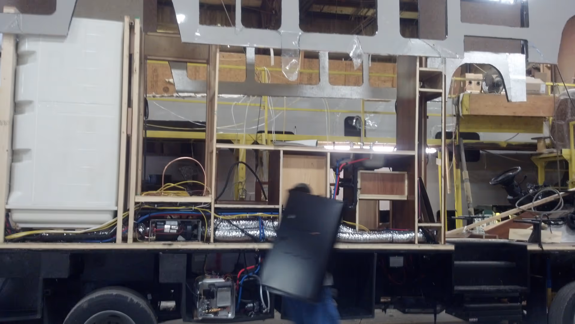 Interior of a motorcoach under construction with exposed framing and wiring.