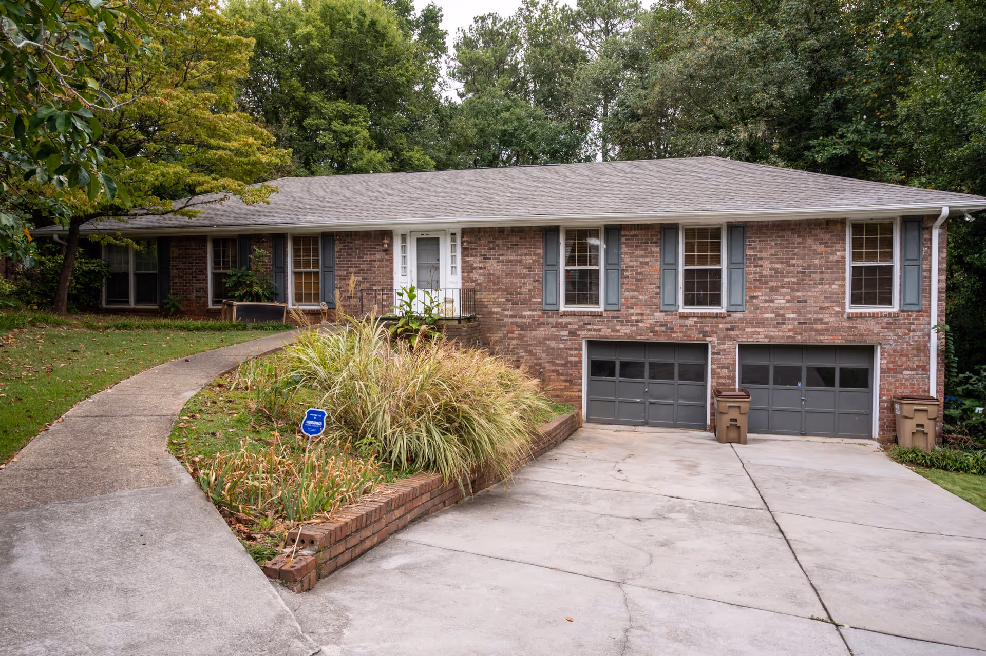 Brick, single-story residence with curved walkway, landscaped front yard, and two-car garage.