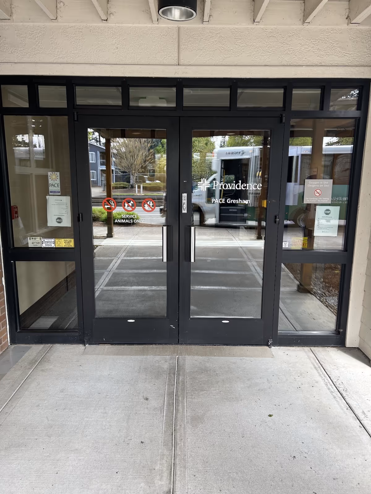 Double glass doors mark the Providence Elderplace entrance with PACE Gresham signage.