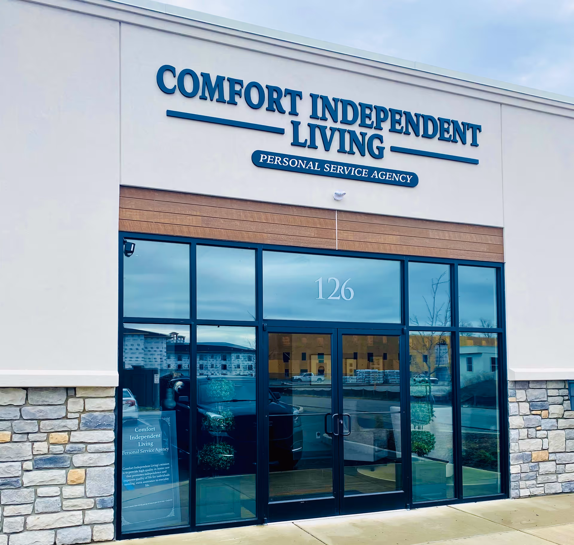 Front exterior of a Comfort Independent Living facility with glass entrance doors.