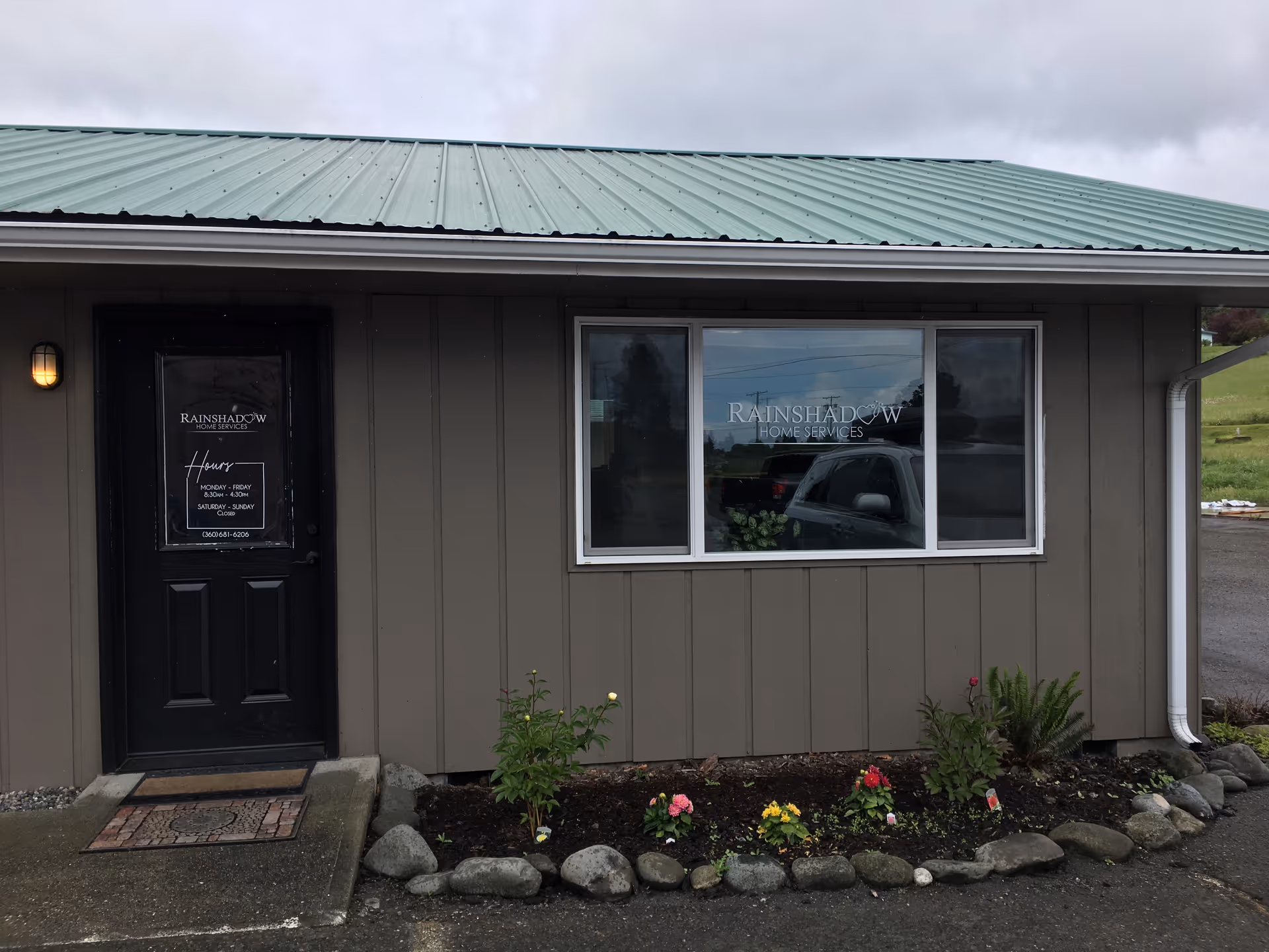 Exterior view of Rainshadow Home Services building with a window, door, and landscaped front yard.