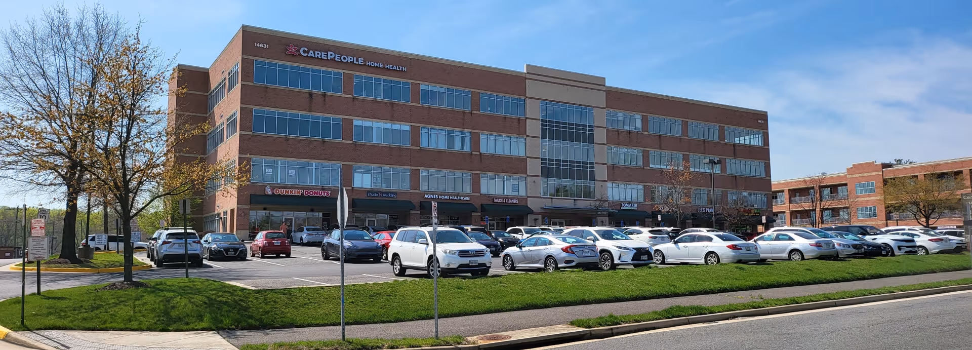 Exterior view of CarePeople Home Health building with a long parking lot in front.