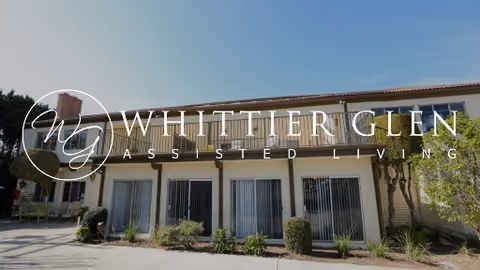 Exterior view of Whittier Glen Assisted Living building with front windows and landscaping.