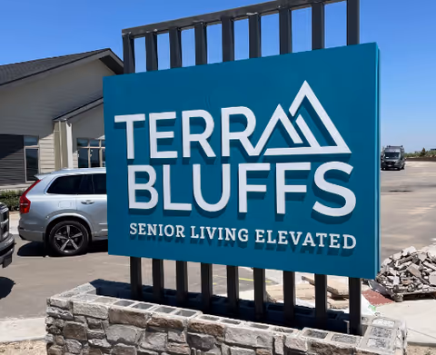 Blue Terra Bluffs sign reading 'Senior Living Elevated' stands outside a building.