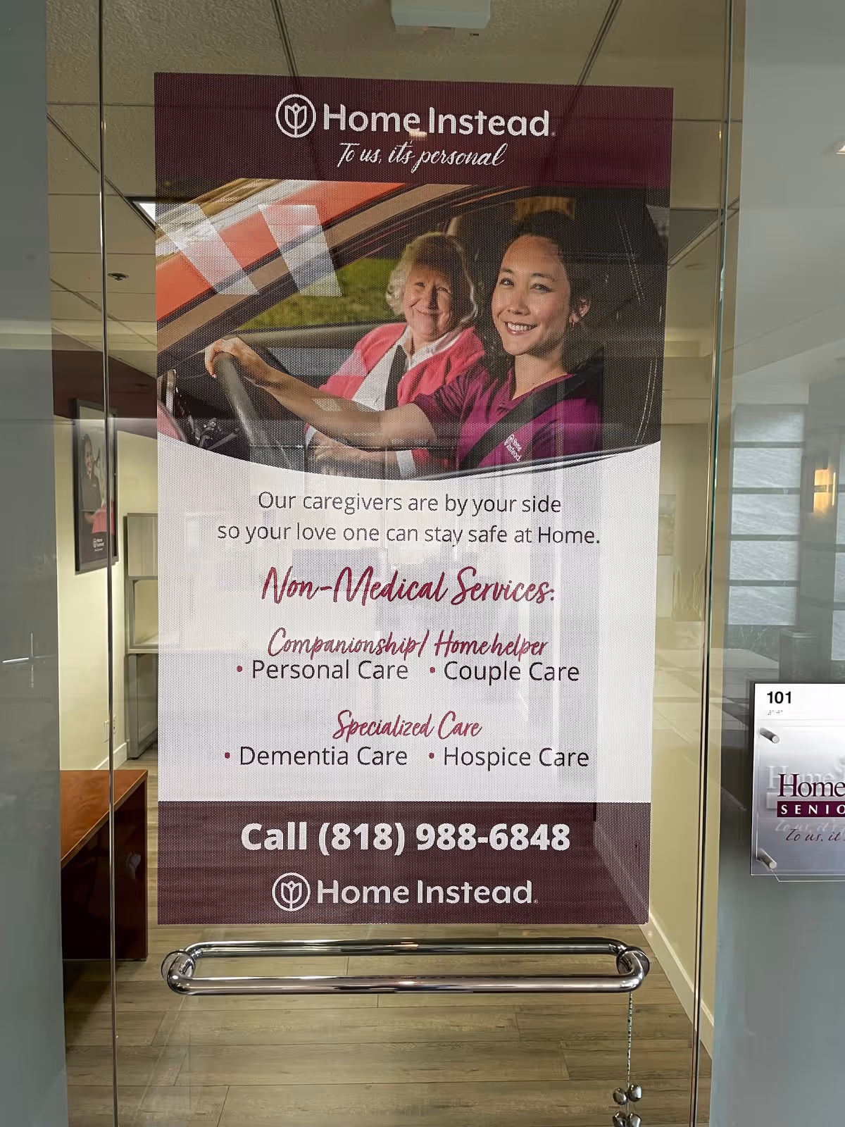 Large Home Instead poster in glass-door entrance promoting non-medical elder care.