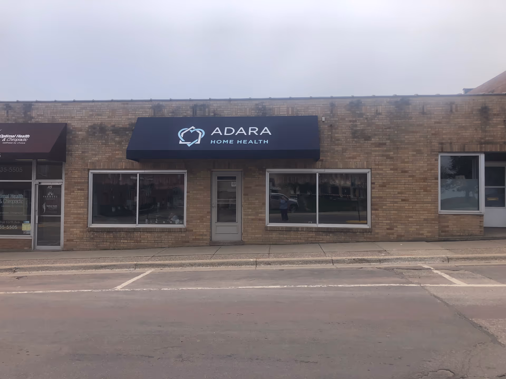 Brick storefront with Adara Home Health sign under a blue awning.