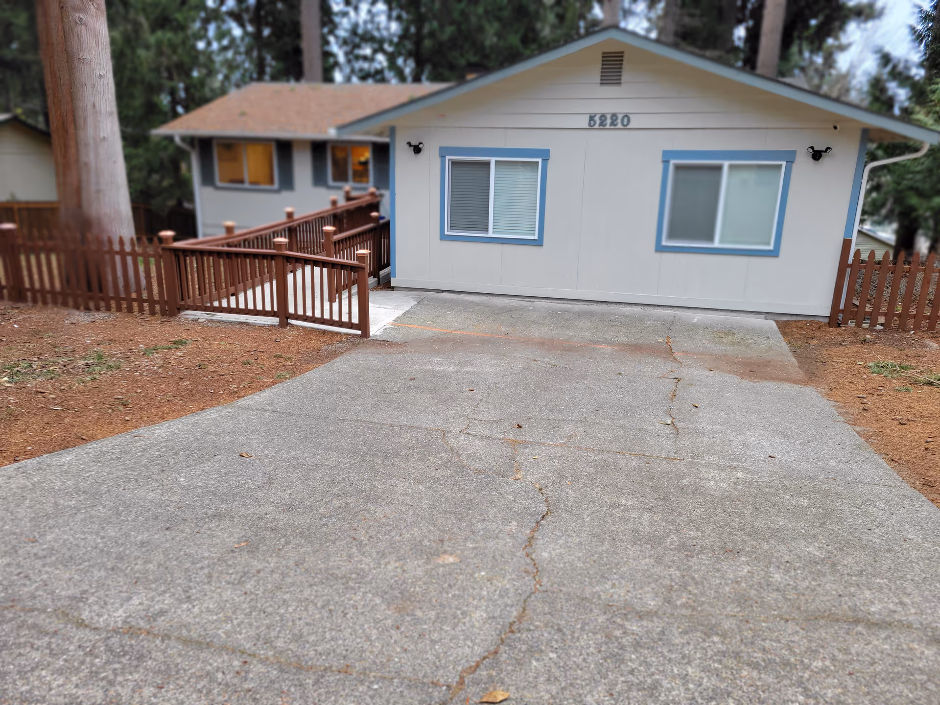 Front view of Marco Adult Family Home LLC with driveway and wooden fence.