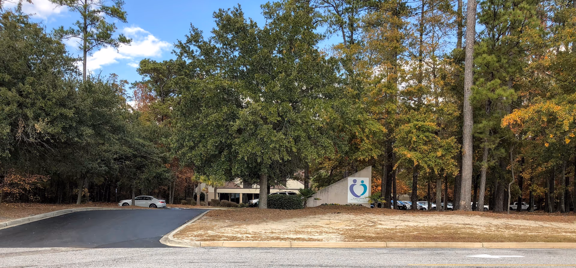 Front exterior of Nightingale's Nursing and Attendants of Florence with trees and parked cars.