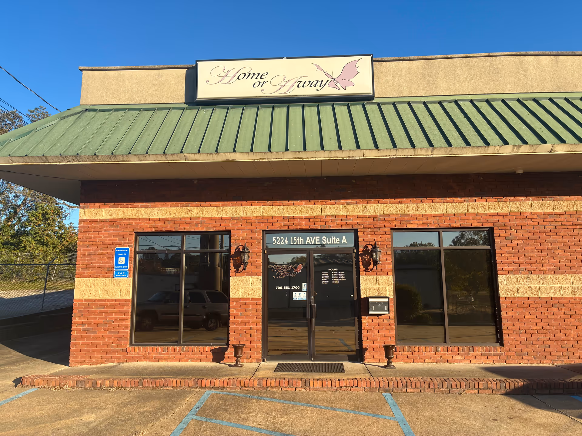 Exterior brick building with a 'Home or Away' sign above glass entrance doors.