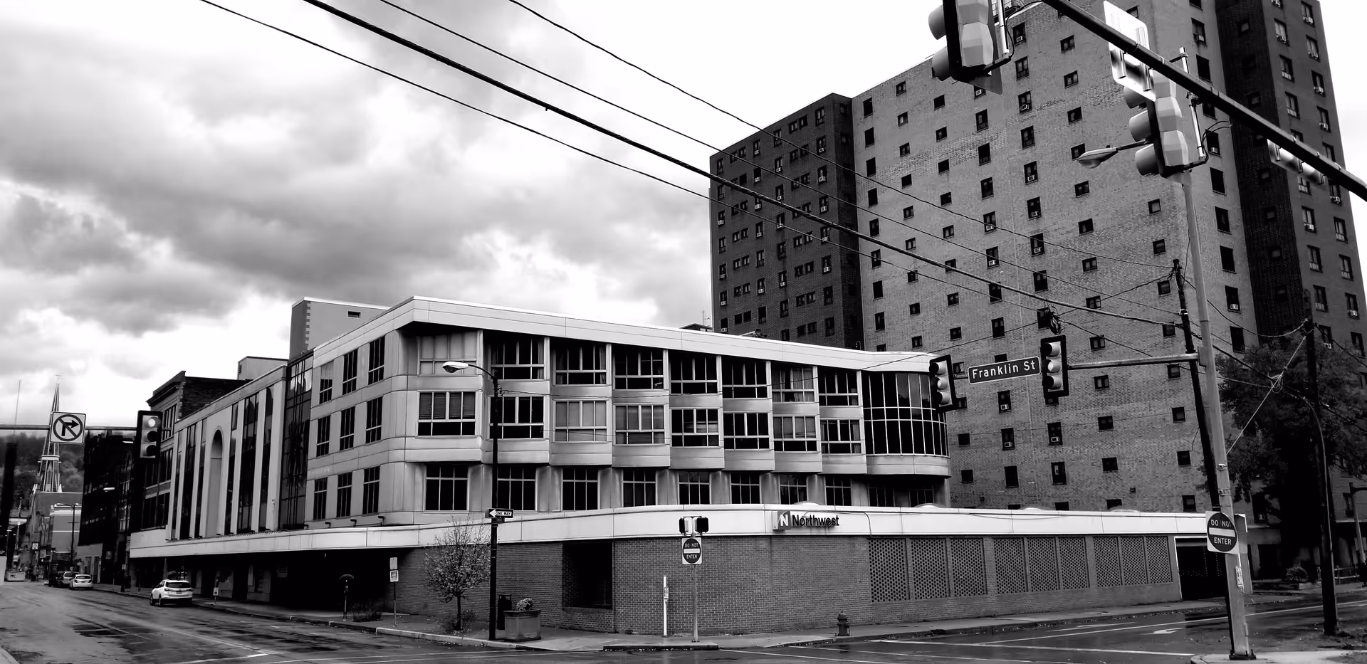 Black-and-white exterior street view of a corner commercial building.
