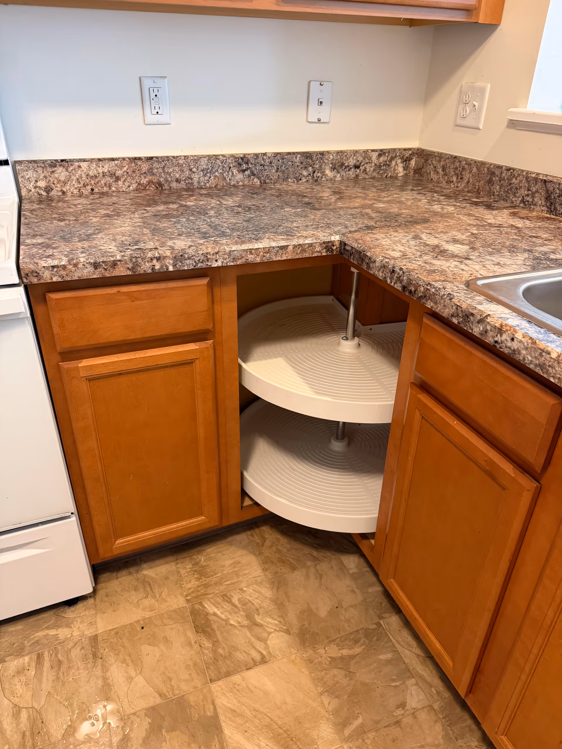 Open corner kitchen with rotating lazy-Susan shelf inside an under-counter cabinet.
