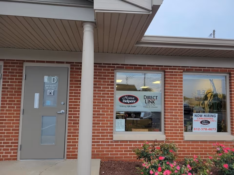 Brick facility storefront with a gray door and two windows displaying Home Helpers signage.