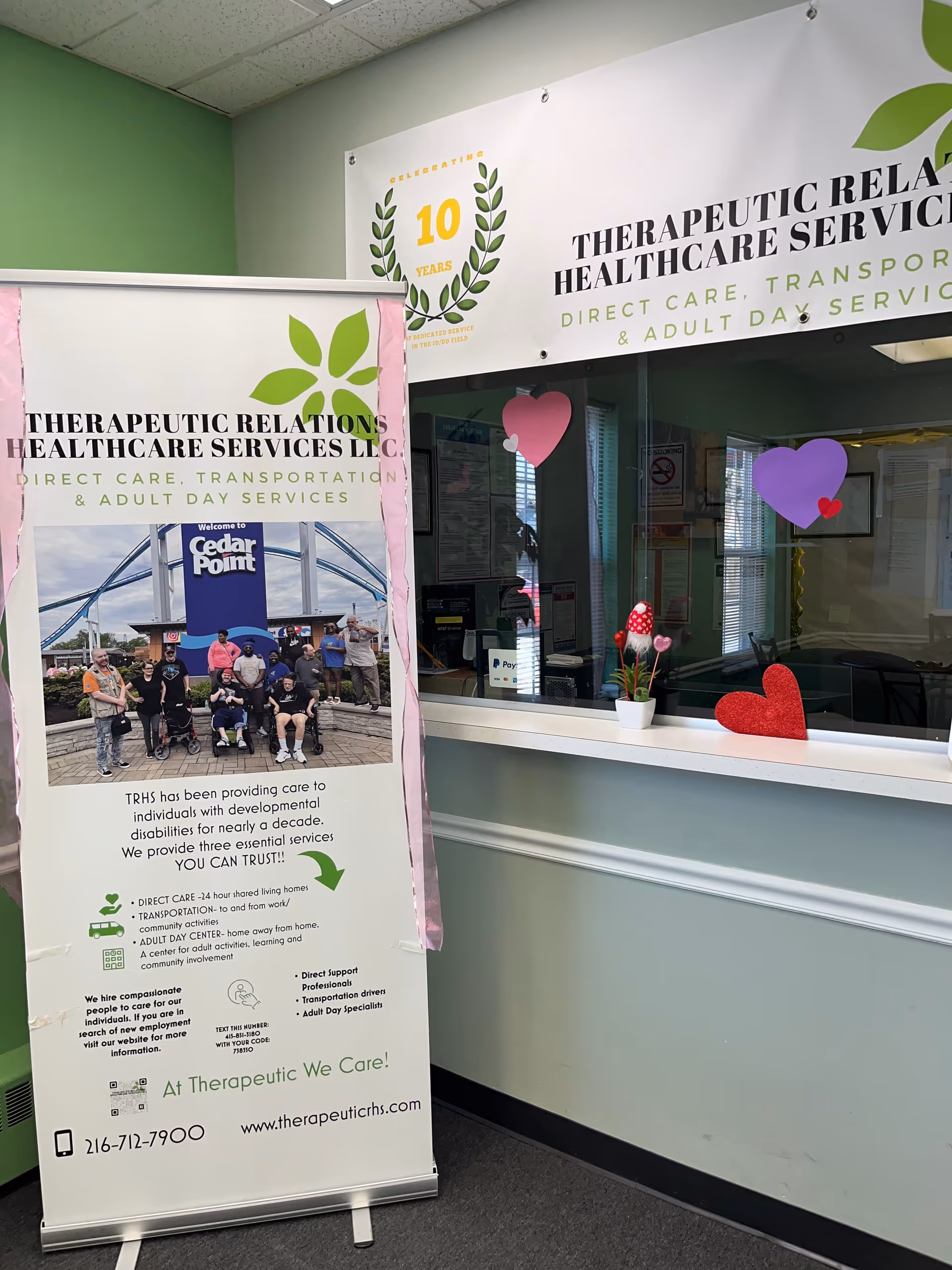 Interior lobby of Therapeutic Relations Healthcare Services LLC with a tall banner and heart decorations.