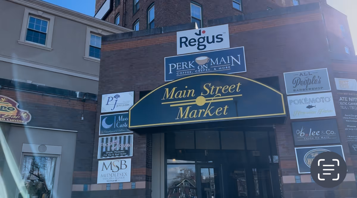 Exterior brick building with Main Street Market sign and surrounding storefront signs.