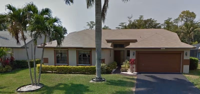 Front exterior of a single-story Havencrest ALF III residence with palm trees and a garage.