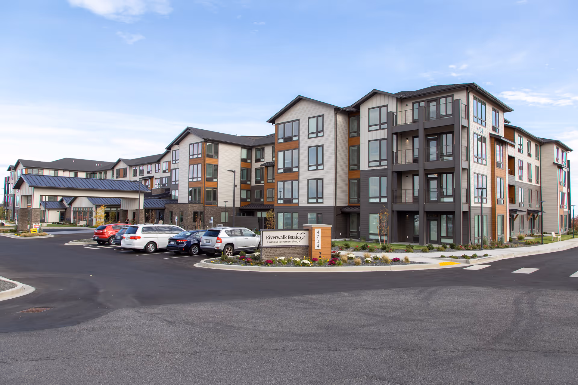 Exterior view of Riverwalk Estates senior living building with parked cars
