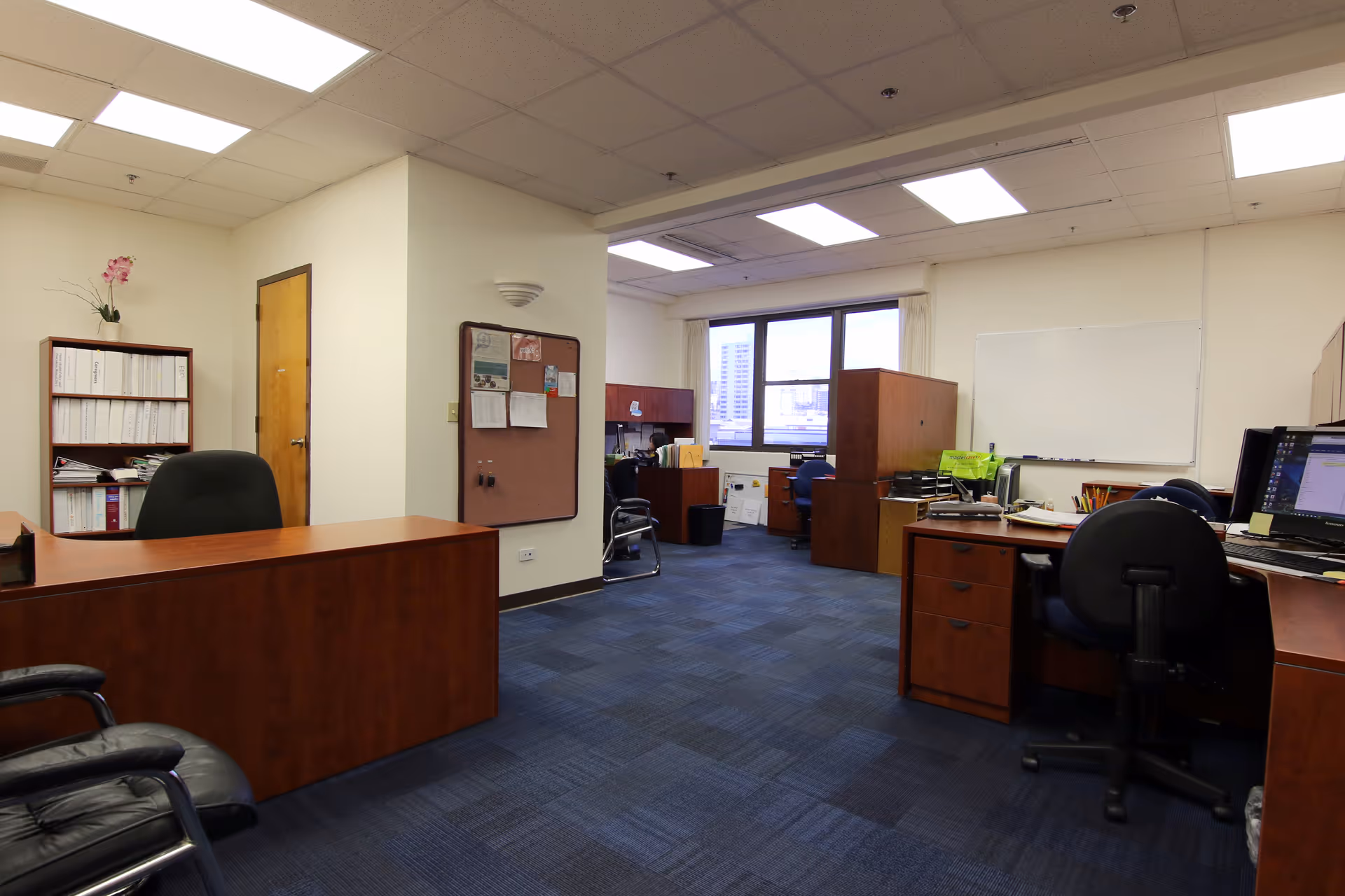 Office area with desks, chairs, filing cabinets, and computer workstations.