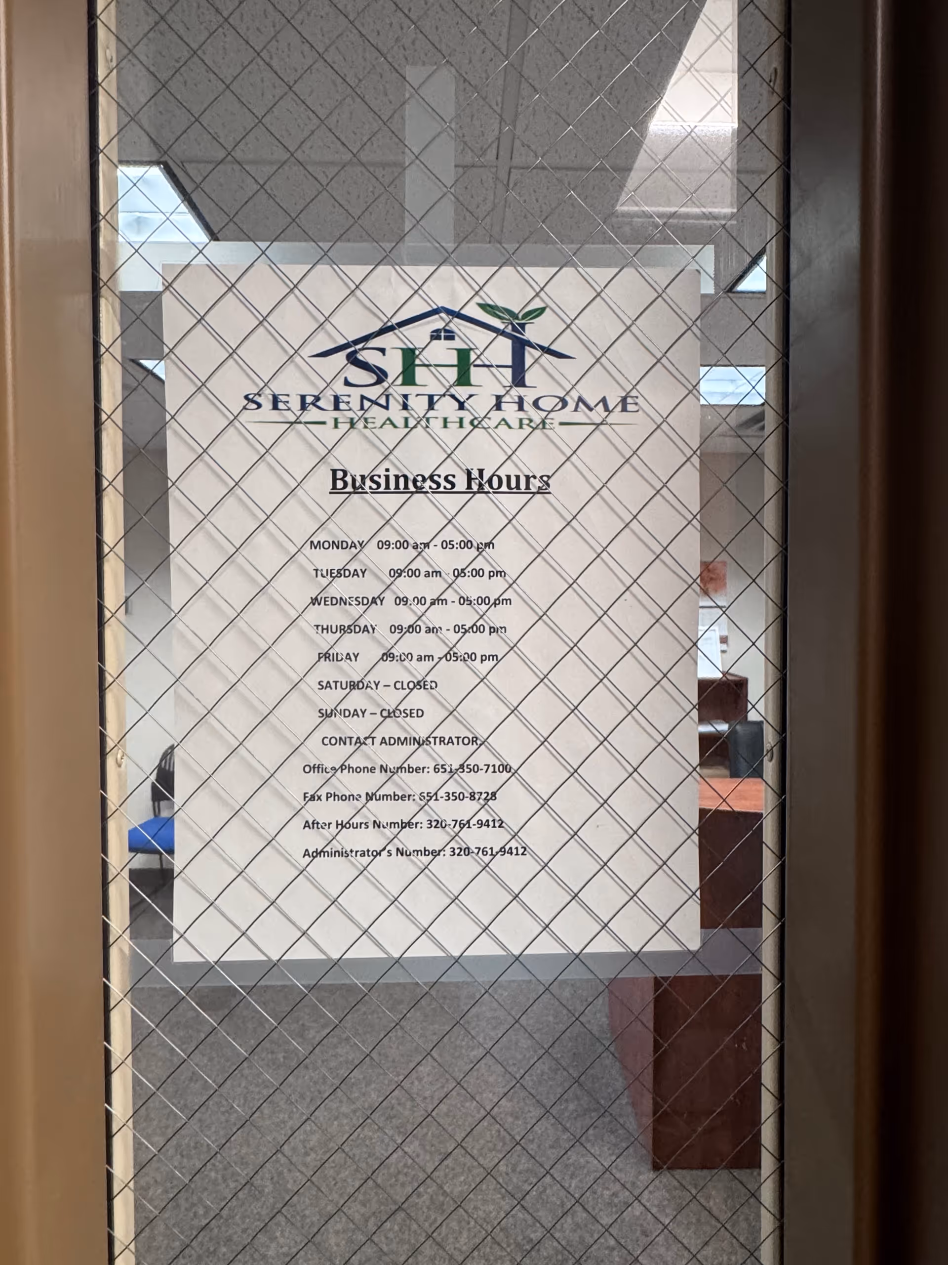 Glass door displays Serenity Home Health Care business hours sign inside