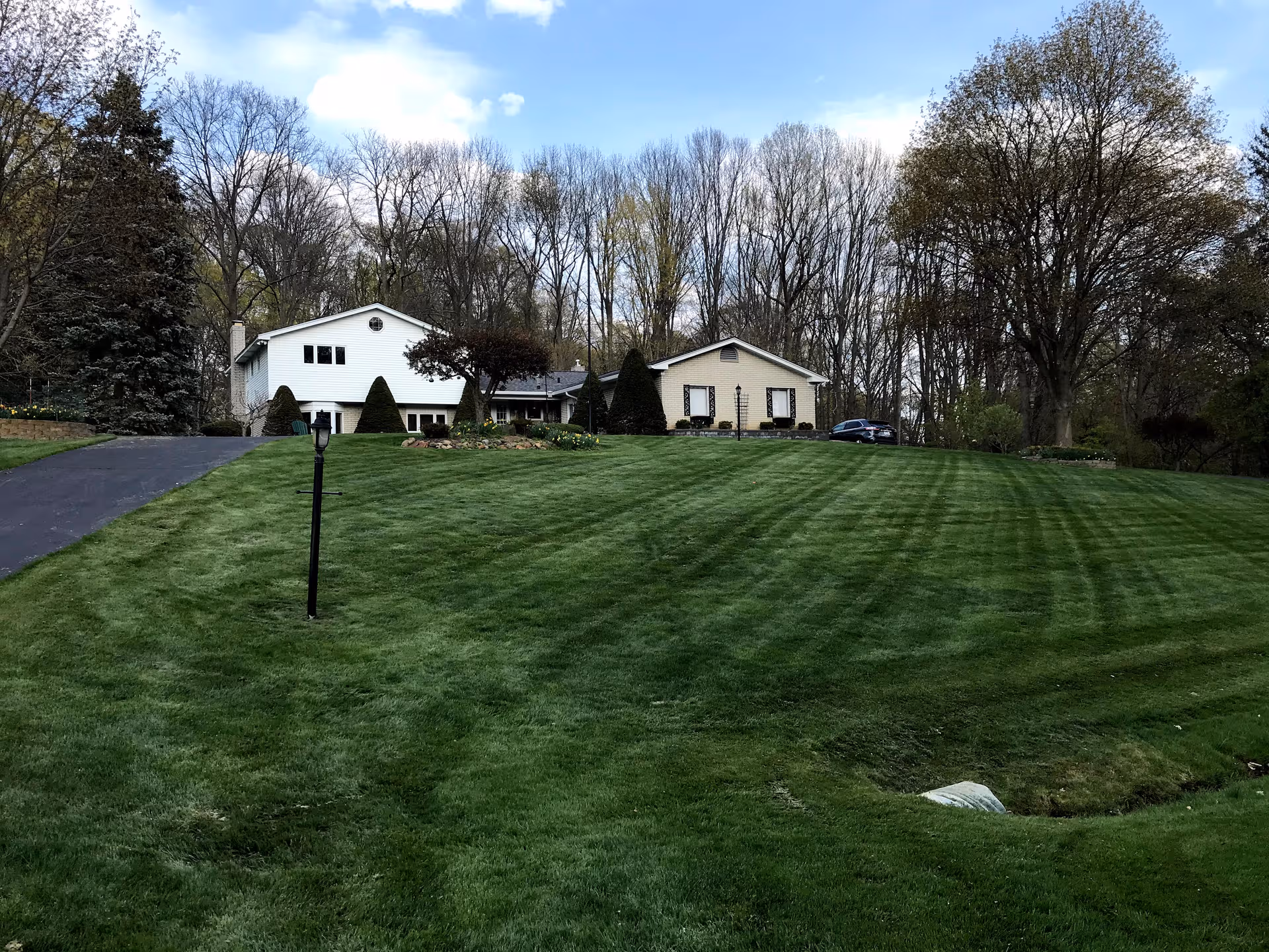 Exterior view of Orchard Manor with a large manicured lawn and trees.