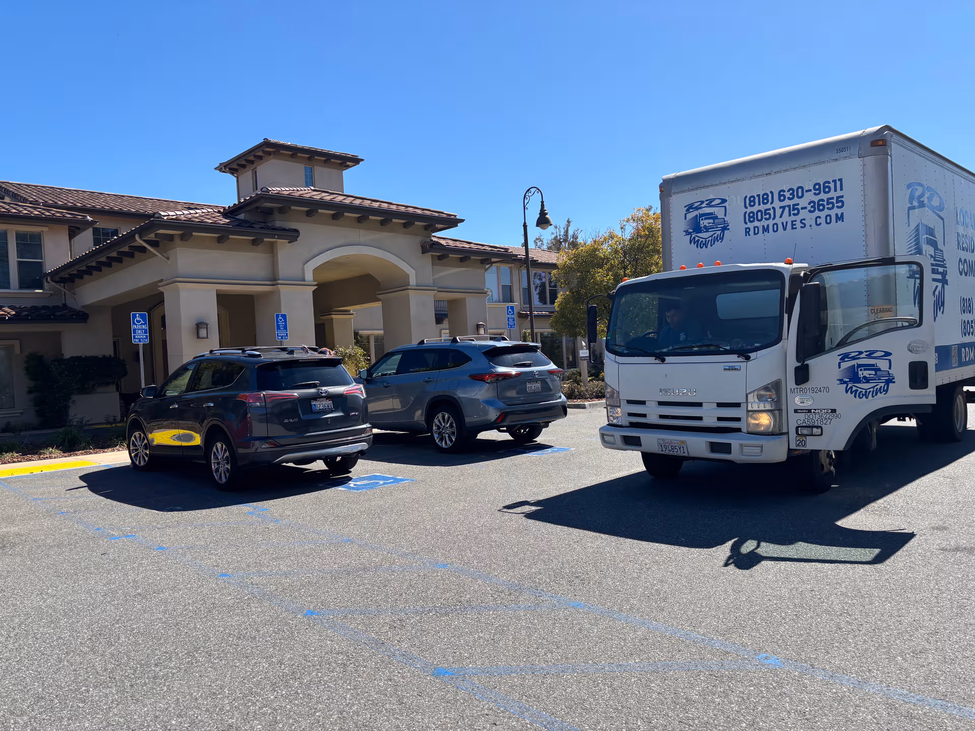 Oakmont of Santa Clarita building front with parked cars and a moving truck