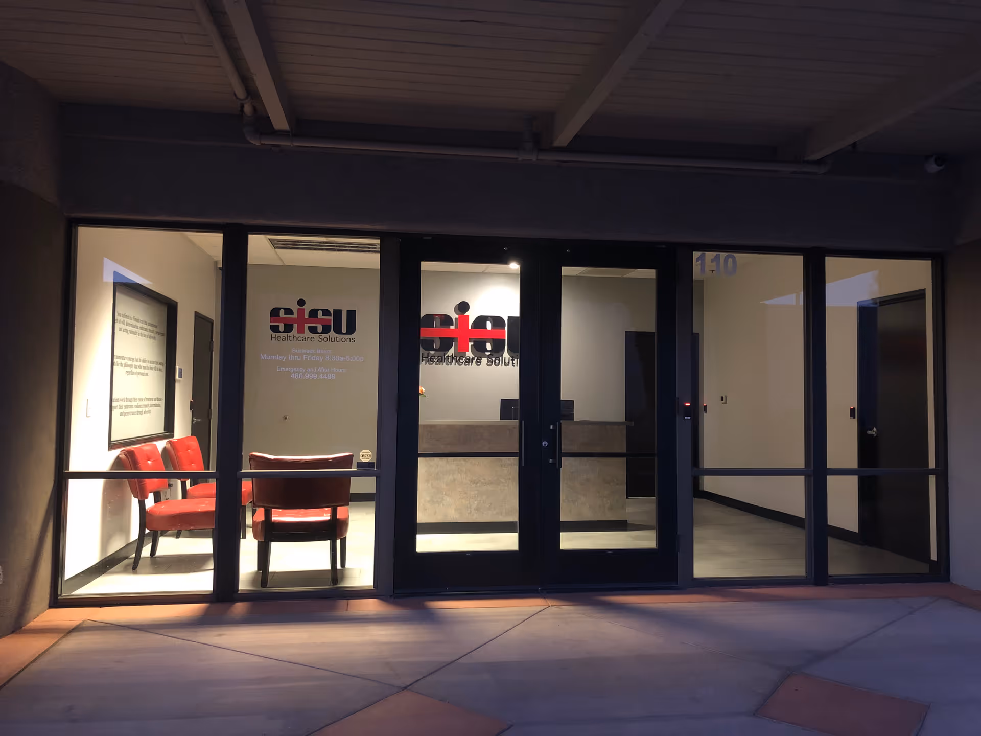 Front view of a building entrance with glass doors and a lobby area.
