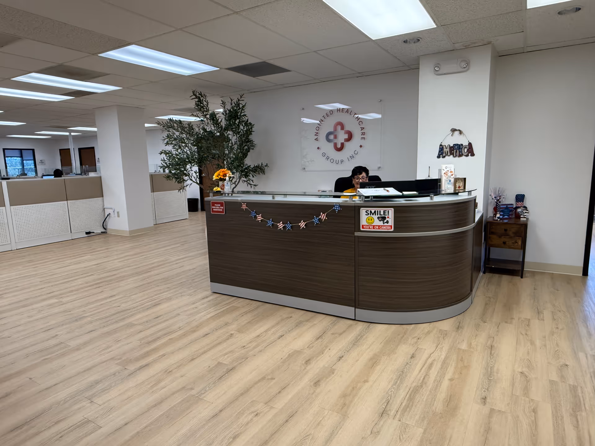 Reception desk in a spacious lobby with wood paneling and a staff member behind it.