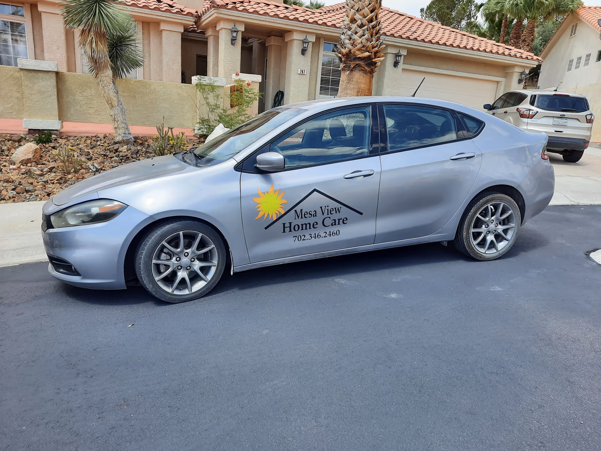 Silver Mesa View Home Care car with logo parked in front of a beige house.