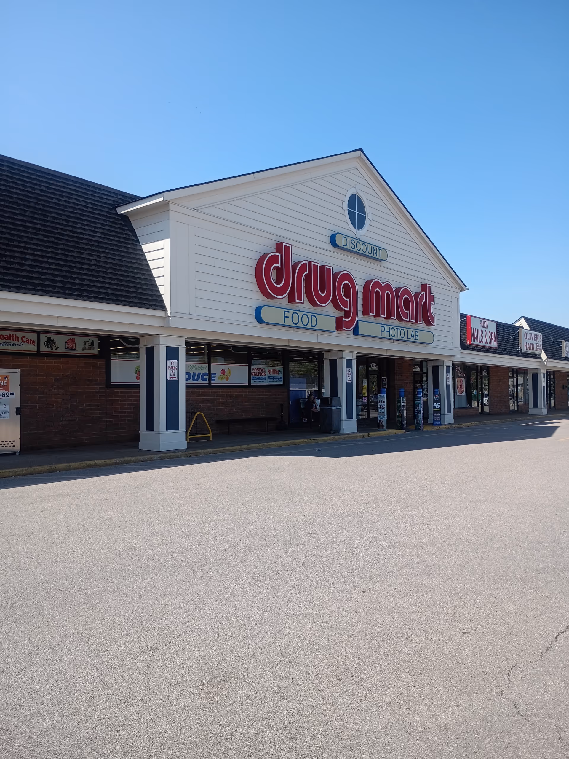 Exterior view of Discount Drug Mart storefront with a large red sign.