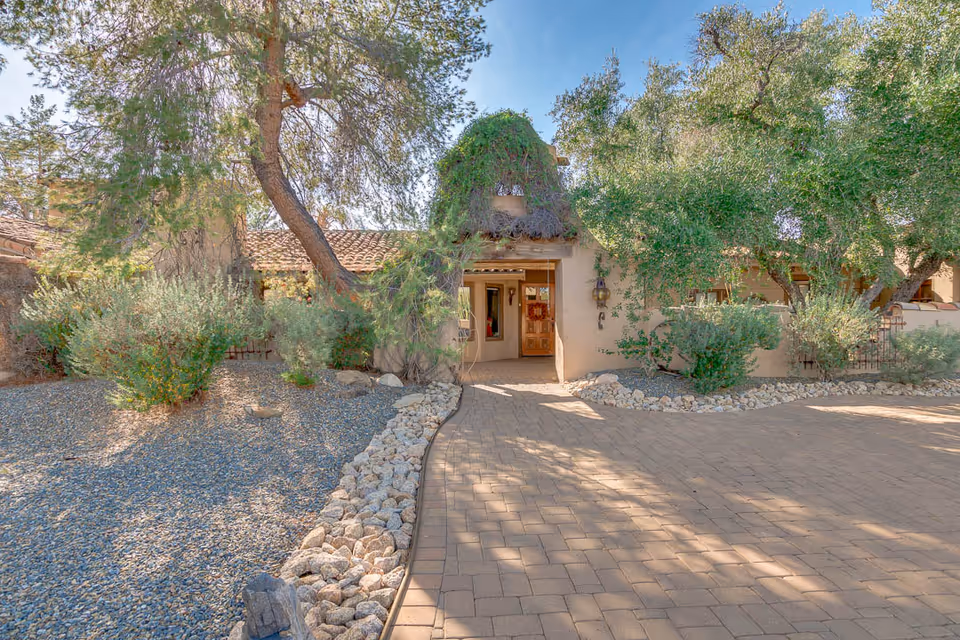 Southwestern-style senior living facility entrance with desert landscaping and a stone-paved walkway