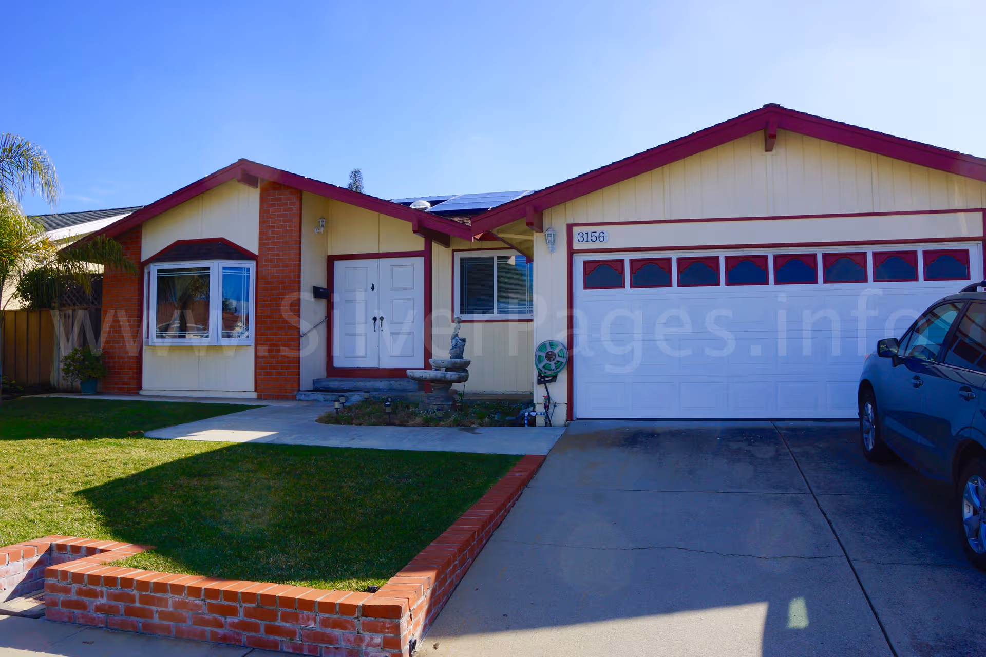 Single-story residential-style facility front with two-car garage and well-kept lawn.