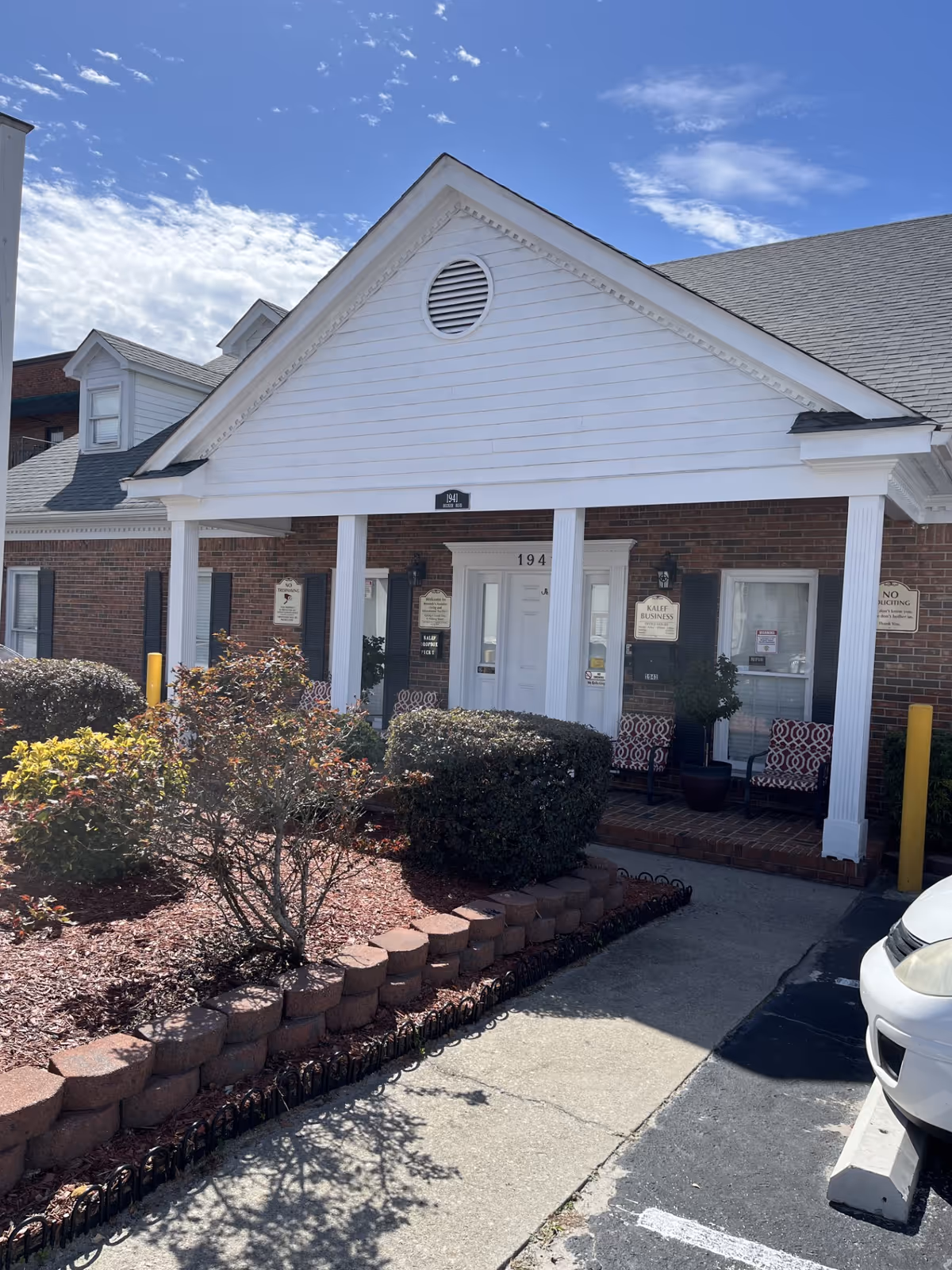 Front view of KALEF Home Care facility with brick facade and white porch columns.