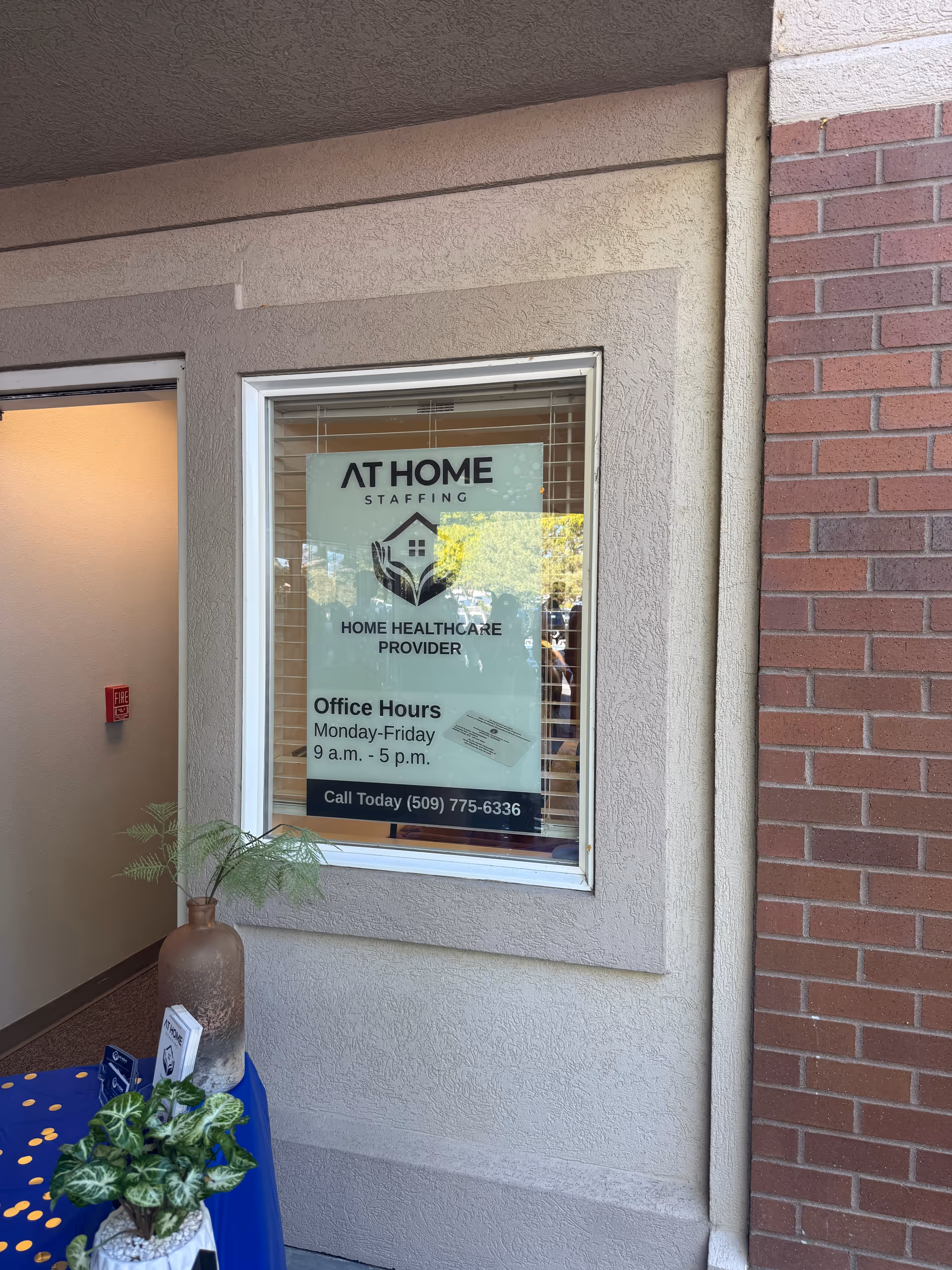 Exterior view of a building front featuring a window sign reading At Home Staffing.
