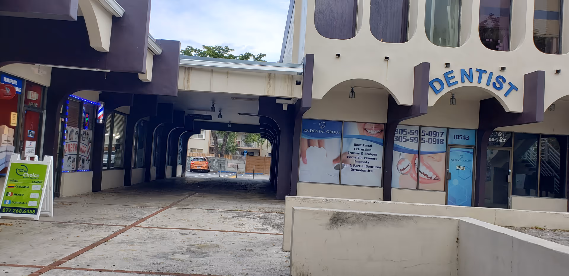Exterior view of a purple and beige building with a dentist sign