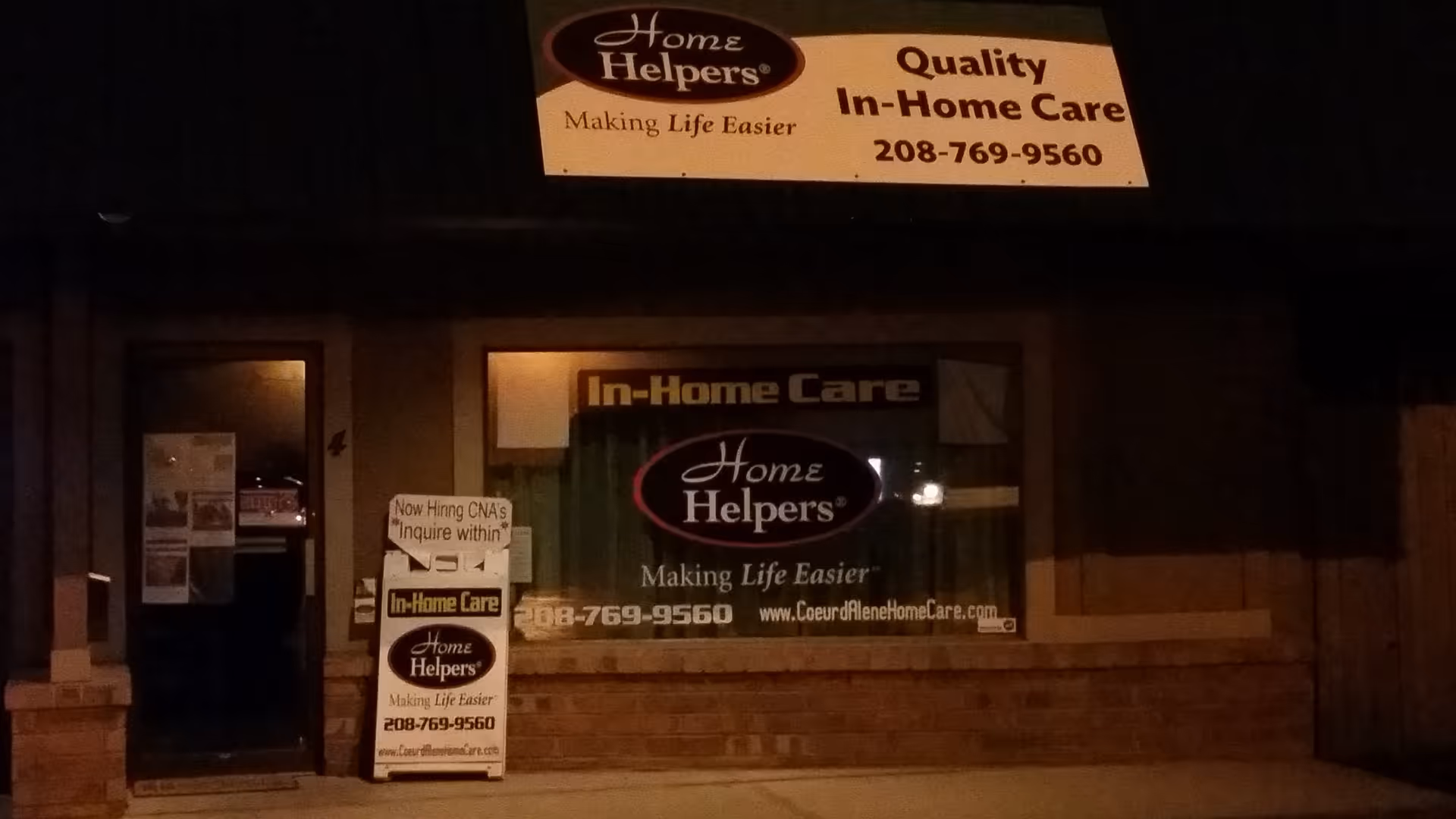 Night exterior of a storefront with Home Helpers in home care signage.