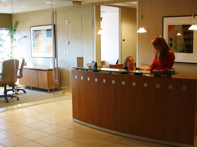 Reception desk in a modern senior living lobby, with staff assisting a resident.