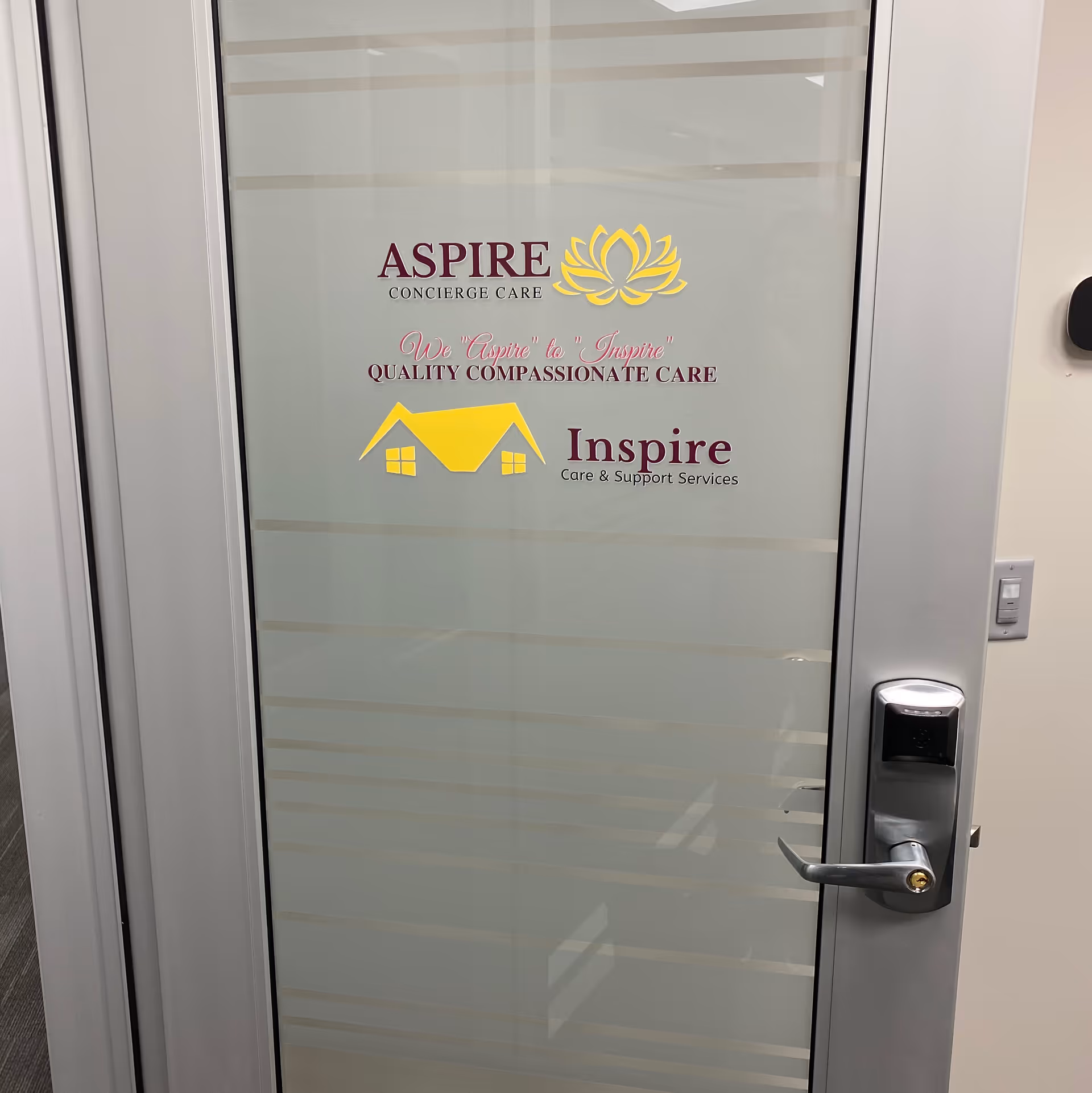 Glass door displaying Inspire Care and Support Services logo with yellow house icon.