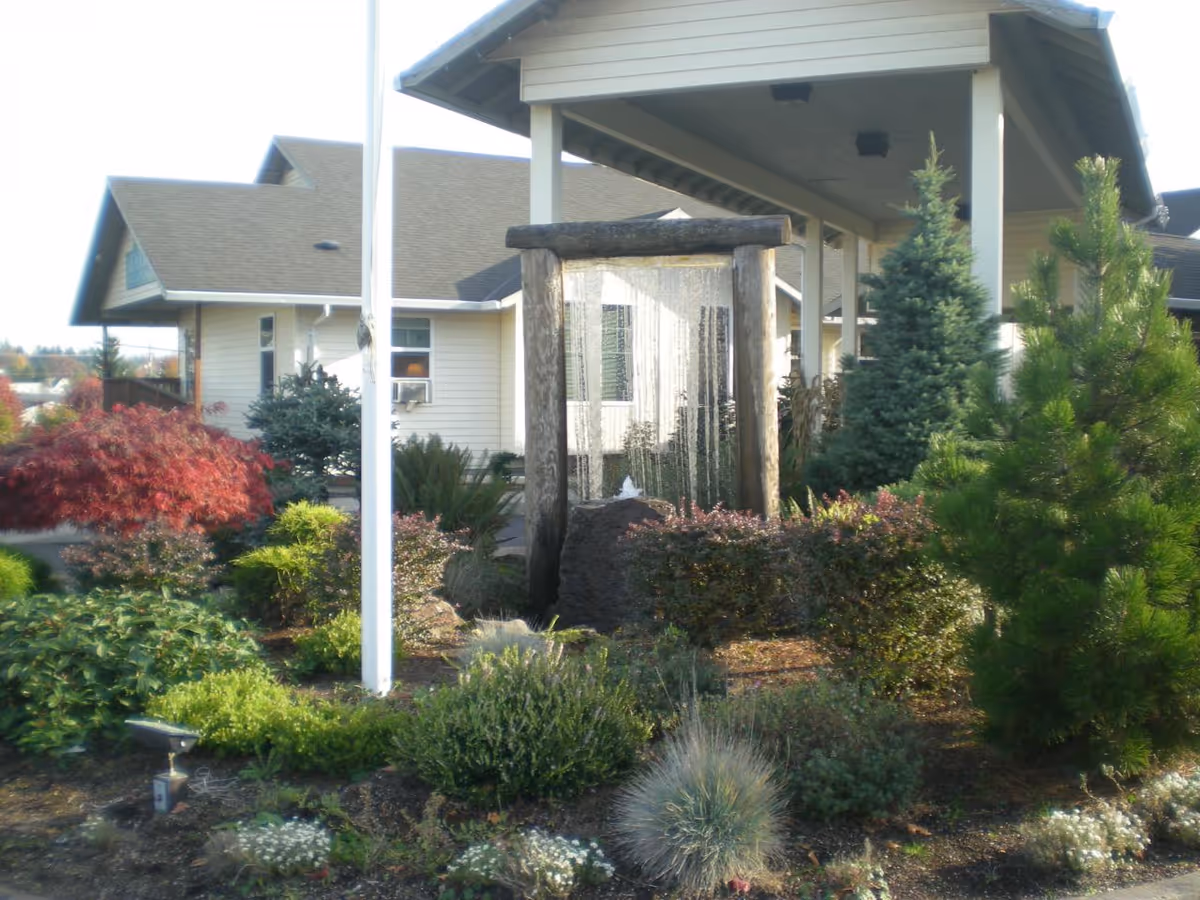 Meadows Courtyard senior living exterior with landscaped garden and covered entrance