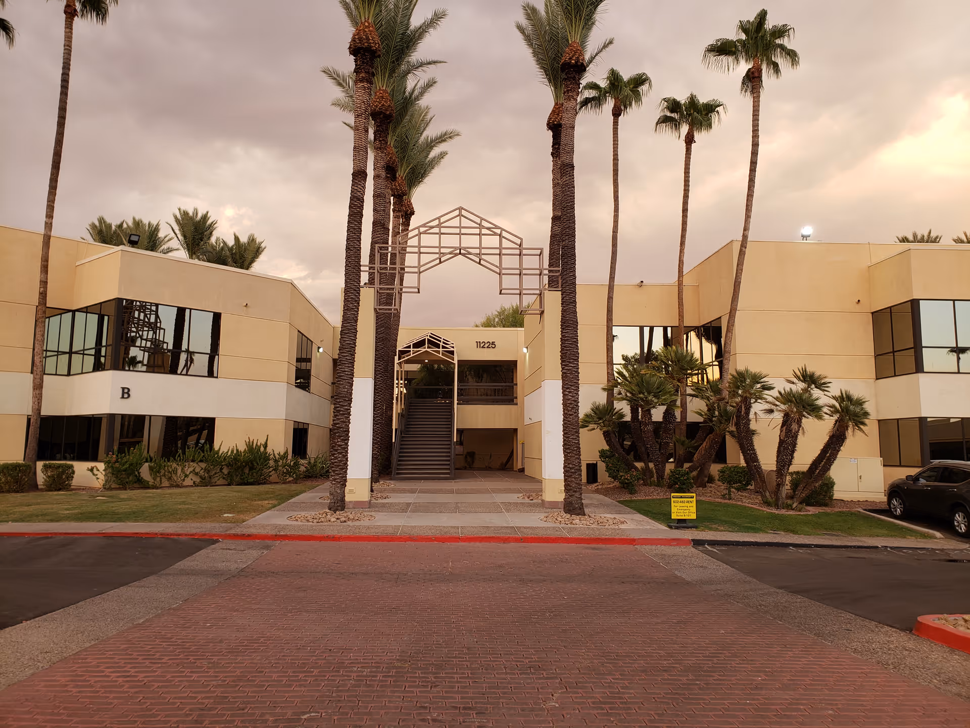 Exterior view of Divine Favour Health Services facility with palm trees and entrance