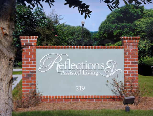 Brick sign for Reflections Assisted Living with landscaping and 219