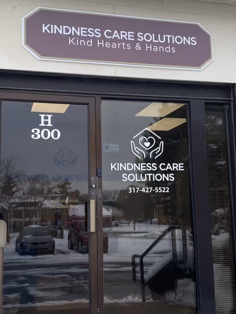 Exterior entrance for Kindness Care Solutions with glass door and logo.