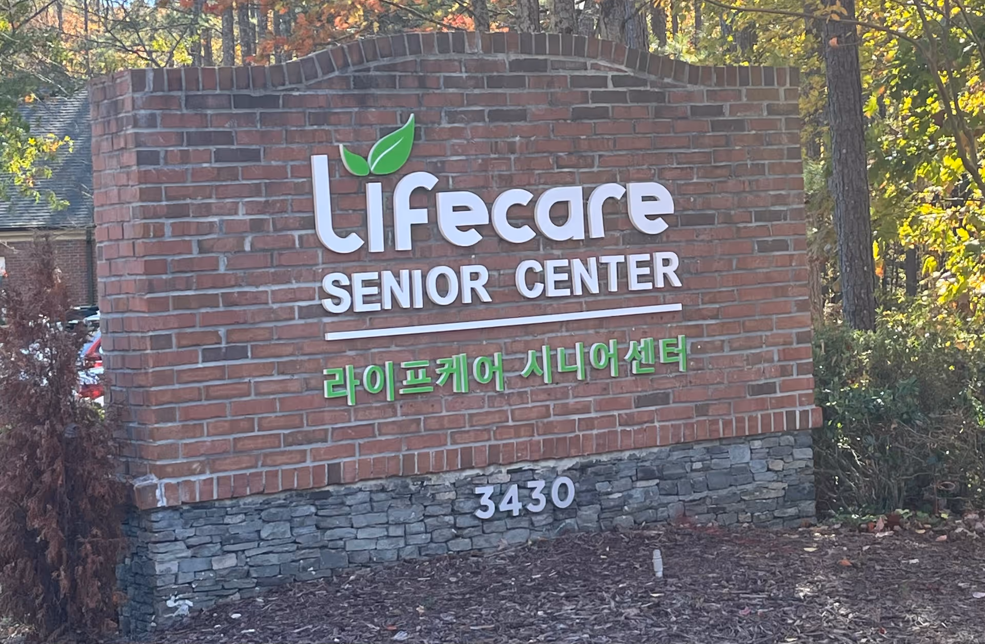 Brick sign reads Lifecare Senior Center with Korean text and address 3430