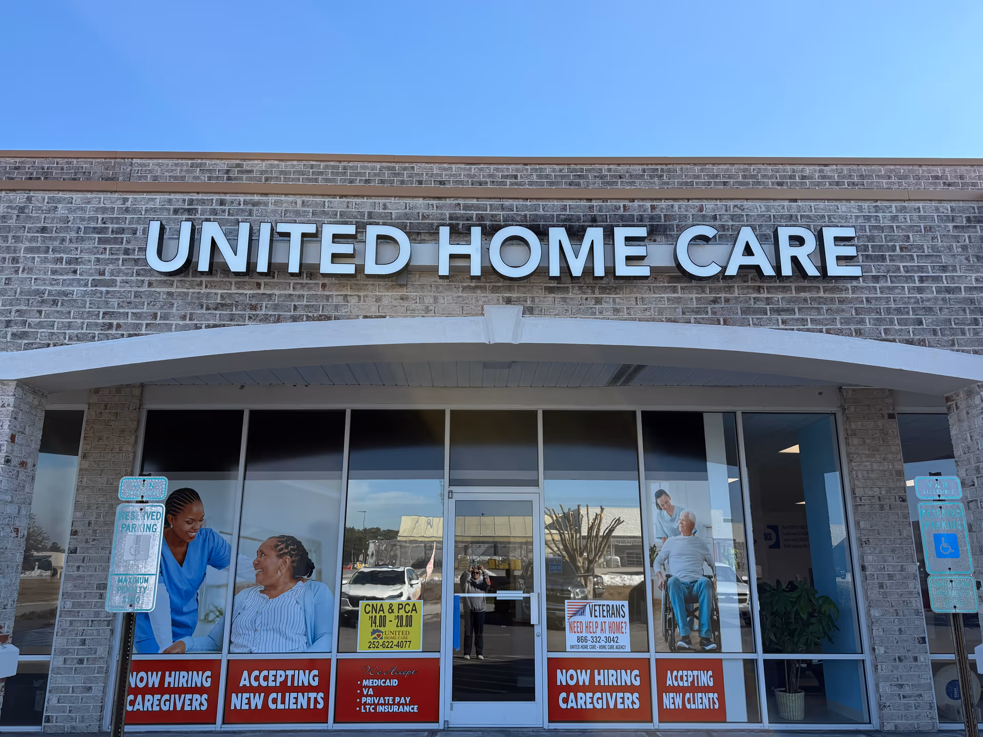 Facade of United Home Care storefront with large windows and recruitment posters