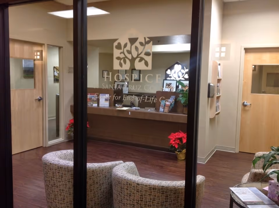 Lobby reception area with glass partition and seating at Hospice of Santa Cruz County.