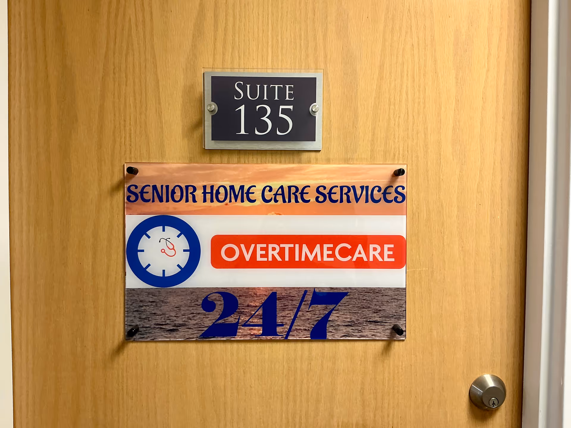 Wooden door with Suite 135 plaque and OVERTIMECARE 24/7 sign